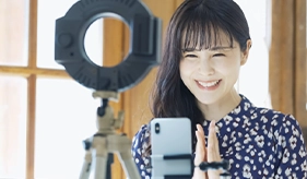 笑顔でライブ配信する女性